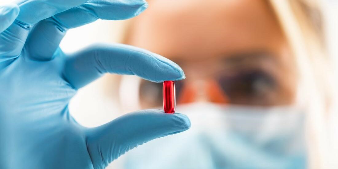 Doctor holding up a red pill Chemotherapy can help treat your cancer, but it has many side effects.